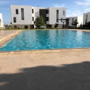 a large blue swimming pool in front of a building at Saltwater Cottage Studio Taghazout Bay Tamourit in Taghazout