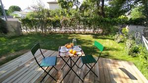 une table et des chaises sur une terrasse dans une arrière-cour dans l'établissement Villa Poète avec jardin 3 Chambres Parking gratuit, à Tournefeuille