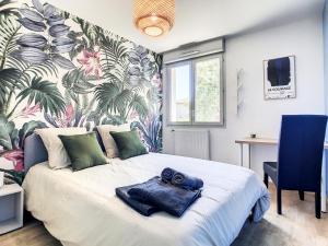 Un dormitorio con una cama con una toalla azul. en Villa Poète avec jardin 3 Chambres Parking gratuit, en Tournefeuille