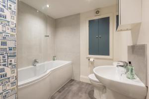 a bathroom with a tub and a toilet and a sink at The Servant’s Quarters in Whitby