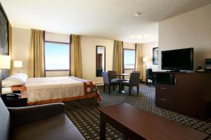 a hotel room with a bed and a television at Super 8 by Wyndham Fox Creek in Fox Creek