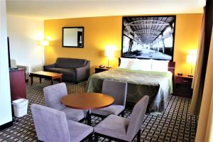 a hotel room with a bed and a table and chairs at Super 8 by Wyndham Fox Creek in Fox Creek
