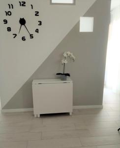 una stanza con orologio e armadietto bianco di DAMASTE' CASA VACANZE PACHINO a Pachino