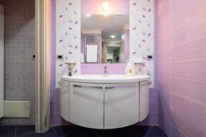 ein Bad mit einem Waschbecken und einem Spiegel in der Unterkunft Fox Holiday Home In The Port in Neapel