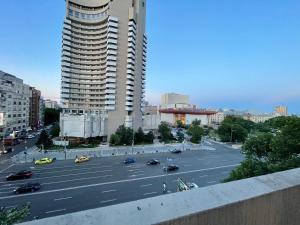 een uitzicht op een parkeerplaats met een groot gebouw bij Gorgeous Apartament with View in Piata Universitatii in Boekarest