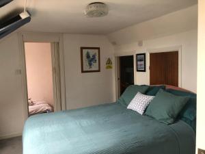 a bedroom with a bed with a blue blanket at Quirky Loft Apartment in Paignton with sea views in Paignton