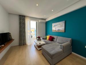 a living room with a couch and a blue wall at Dani's Apartments in Sarandë