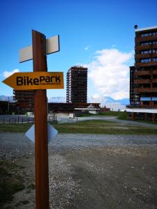 un panneau indiquant un parc à vélos sur un poteau dans l'établissement Studio 1 pièce PLAGNE VILLAGE 4 personnes 2050 M PIED DES PISTES, à Plagne Villages