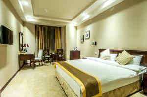 a hotel room with a large bed and a desk at Diamond Hotel Yerevan in Yerevan