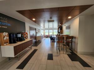 um átrio de um café com mesas e cadeiras em Holiday Inn Express Hotel & Suites Rochester, an IHG Hotel em Rochester