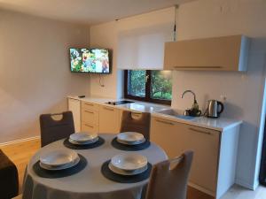 a kitchen with a table with four plates on it at Apartmaji Pregelj in Koper