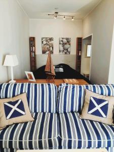 a living room with a couch with blue and white stripes at Lillmåsen Naantali - atmospheric and very comfy studio in Naantali