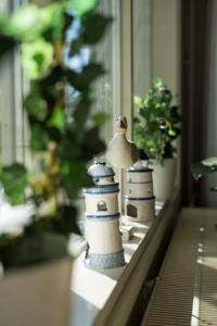 dos figuritas de un faro de juguete sentadas en el alféizar de una ventana en Lillmåsen Naantali - atmospheric and very comfy studio, en Naantali