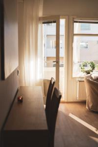 una mesa y sillas en una sala de estar con ventana en Lillmåsen Naantali - atmospheric and very comfy studio, en Naantali