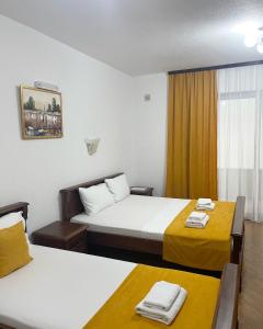 a hotel room with two beds and a window at Apartmani Sejla in Dobra Voda