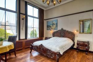 a bedroom with a bed and a table and windows at Hotel Pension 't Huys Grol in Renesse