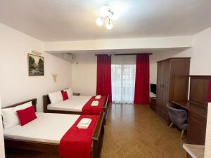 a hotel room with two beds and a tv at Apartmani Sejla in Dobra Voda