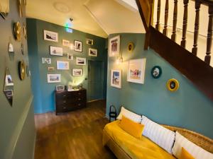 a living room with a yellow couch and a staircase at Hotel du Parc in Dinard
