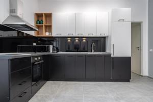 eine Küche mit schwarz-weißen Schränken und Geräten in der Unterkunft Relax Apartament in Piata Universitatii in Bukarest