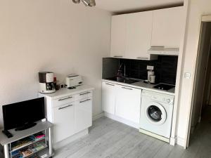 een keuken met een wasmachine en een wasmachine bij Lumineux studio vue mer in Sainte-Maxime
