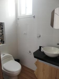 a bathroom with a white toilet and a sink at Hermoso apartamento nuevo con estacionamiento gratuito in San Gil