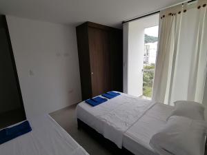 a bedroom with a bed and a large window at Hermoso apartamento nuevo con estacionamiento gratuito in San Gil