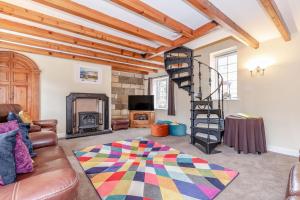 sala de estar con chimenea y escalera de caracol en Brincliffe Cottage en Robin Hood's Bay