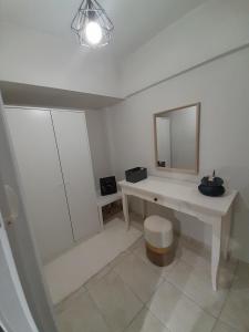 a white bathroom with a sink and a mirror at Cocomelo Apts 2 in Heraklio