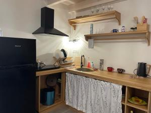 a kitchen with a counter with a sink and a refrigerator at Valeria’s Apartments in Sinarádes +15 photos