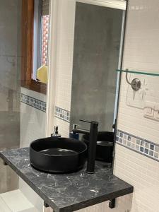 ein Badezimmer mit einem schwarzen Waschbecken auf der Theke in der Unterkunft APARTAMENTOS TURÍSTICOS, PONCE DE LEÓN, Deluxe in Ronda