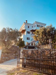 a building with a gate in front of it at Sun Touch Pelion Rooms in Kala Nera
