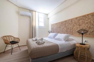 a bedroom with a large bed and a chair at Ethereal Stay in Spetses