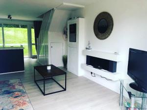 a living room with a flat screen tv and a table at Newquay Holiday Home in Newquay