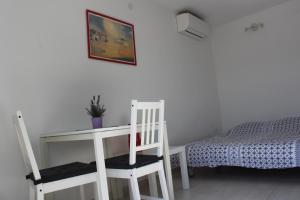 a bedroom with a desk and two chairs and a bed at Apartments Estelle in Pula