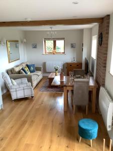 a living room with a table and a couch at Woodcutters Barn, overlooking Ledbury & Malvern Hills in Ledbury