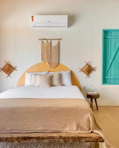 a bedroom with a bed with a wooden headboard at Vila da Falésia in Corumbau