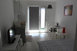 a living room with a kitchen and a dining table at Apartments Estelle in Pula