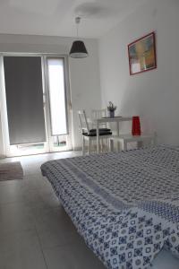 a bedroom with a bed and a table and a window at Apartments Estelle in Pula