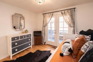 a bedroom with a bed and a dresser and a mirror at BEkiND Cottage in Bend