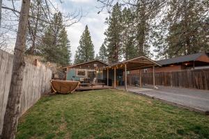 a backyard with a fence and a house at BEkiND Cottage in Bend