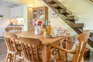 a kitchen with a wooden table with flowers on it at Sleepy Hollow in Ironbridge