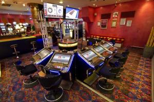 a casino with a bunch of slot machines in a room at Hotel Le Phoebus Garden & Spa in Gruissan