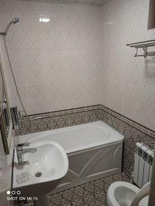 ein Badezimmer mit einer Badewanne und einem Waschbecken in der Unterkunft Oybinokh hotel in Buxoro