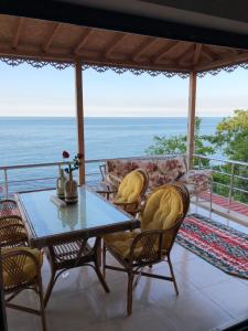 Villa Laila Trabzon في طرابزون: طاولة وكراسي على شرفة مع المحيط