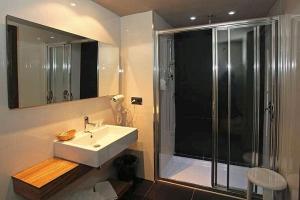 a bathroom with a sink and a glass shower at Hotel Restaurante Revestido in Escalona +14 photos