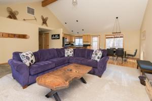 a living room with a purple couch and a wooden coffee table at The Quails Nest in Bend