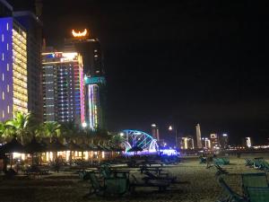 una spiaggia con sedie e edifici di notte di MUONG THANH APARTMENT - 2BR a Da Nang