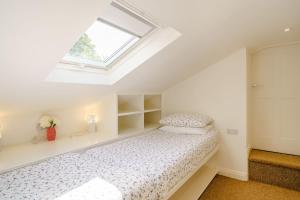 a white bedroom with a bed and a window at Hawkrigg Cottage in Barbon