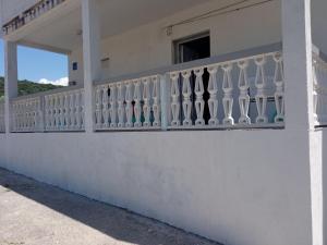 a white balcony of a house with a window at Apartment Mia in Rab