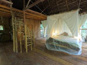 1 dormitorio con 1 cama en una habitación con suelo de madera en Enchanting Jungle Villa — UMARI en Iquitos